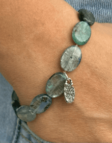 kyanite pebble beaded bracelet with a hammered Tree of Life silver charm on wrist, handmade artisan jewelry