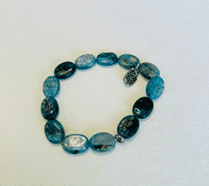 kyanite pebble beaded bracelet with a hammered Tree of Life silver charm on wrist, handmade artisan jewelry