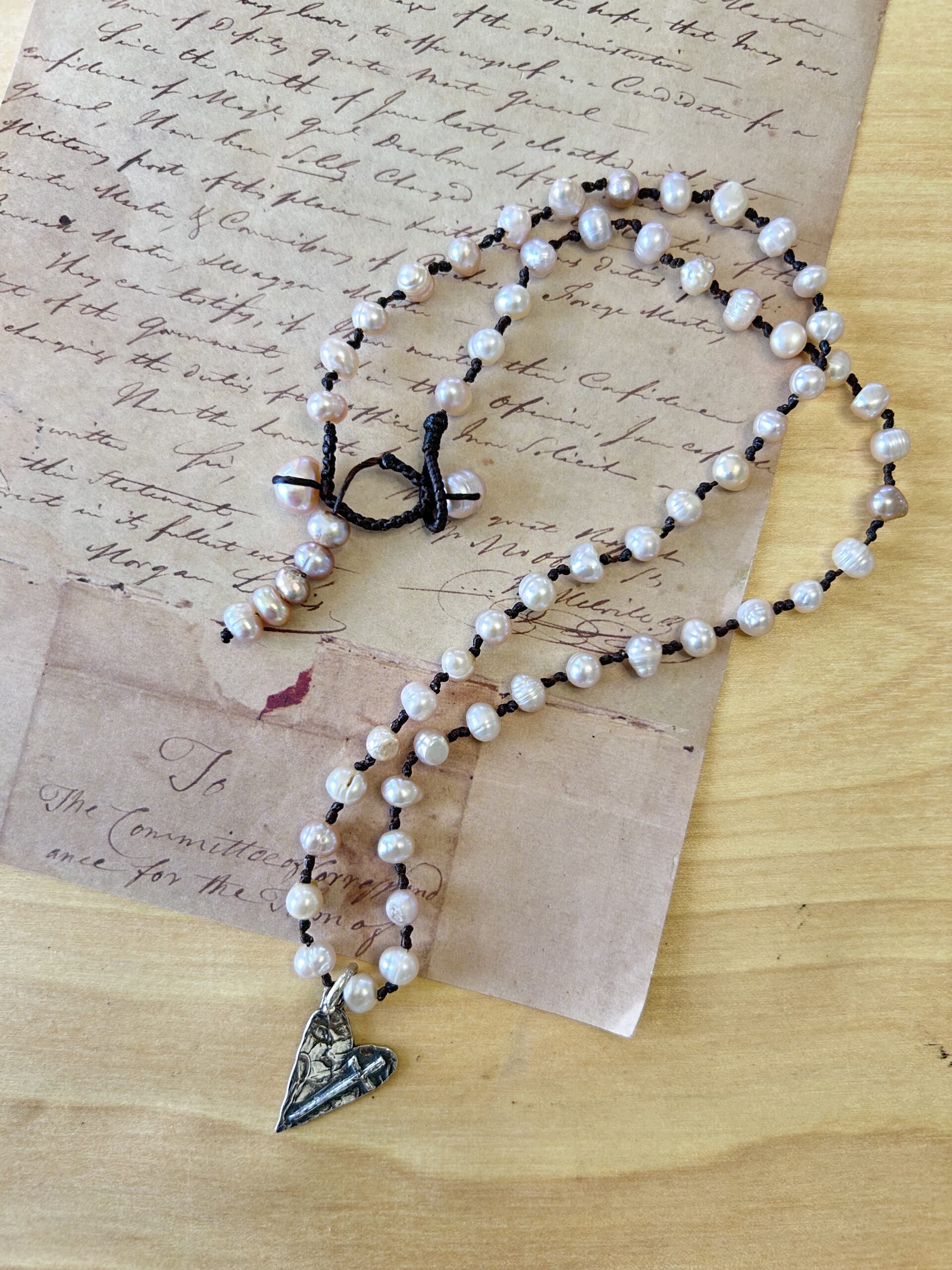 pearl necklace with hand-hammered sterling silver heart and small cross